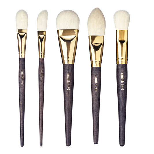 A set of five different sized Smith Cosmetics face makeup brushes with gold ferrules and dark wood handles, displayed side by side